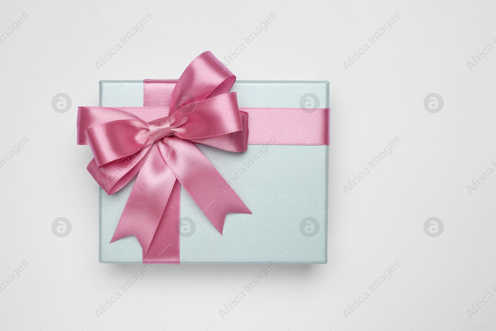 Photo of Gift box with pink bow on light grey background, top view