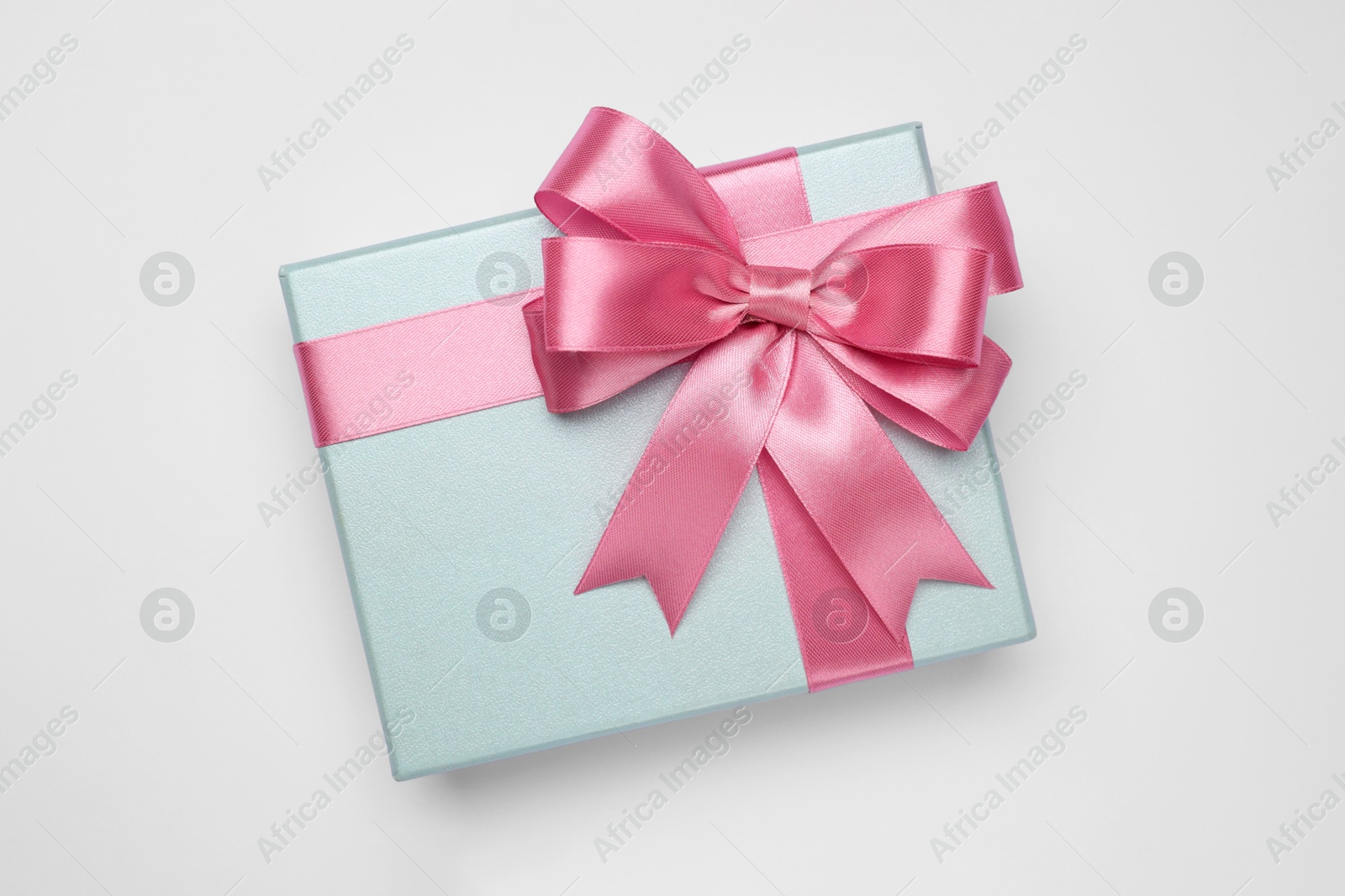 Photo of Gift box with pink bow on light grey background, top view