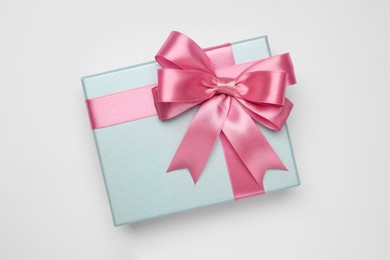 Photo of Gift box with pink bow on light grey background, top view