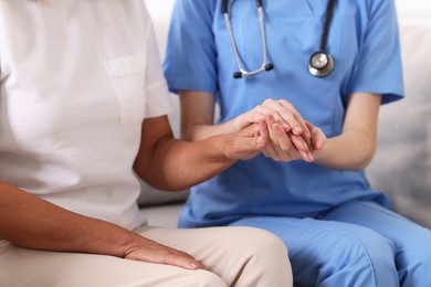 Photo of Healthcare worker supporting senior patient indoors, closeup