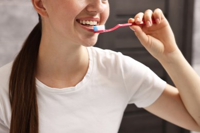 Woman brushing her teeth in bathroom, closeup