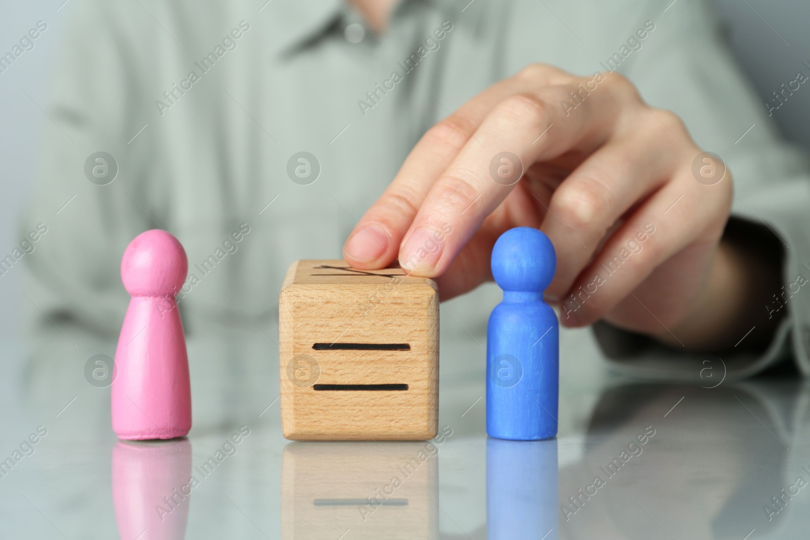 Photo of Gender equality concept. Woman with male and female figures at grey table, closeup