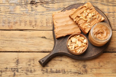 Photo of Delicious sandwiches with peanut butter and fresh nuts on wooden table, top view. Space for text