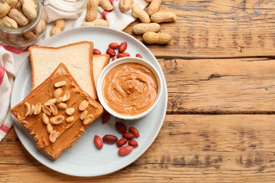 Photo of Delicious sandwich with peanut butter and fresh nuts on wooden table, flat lay. Space for text