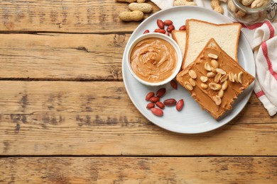 Photo of Delicious sandwich with peanut butter and fresh nuts on wooden table, flat lay. Space for text