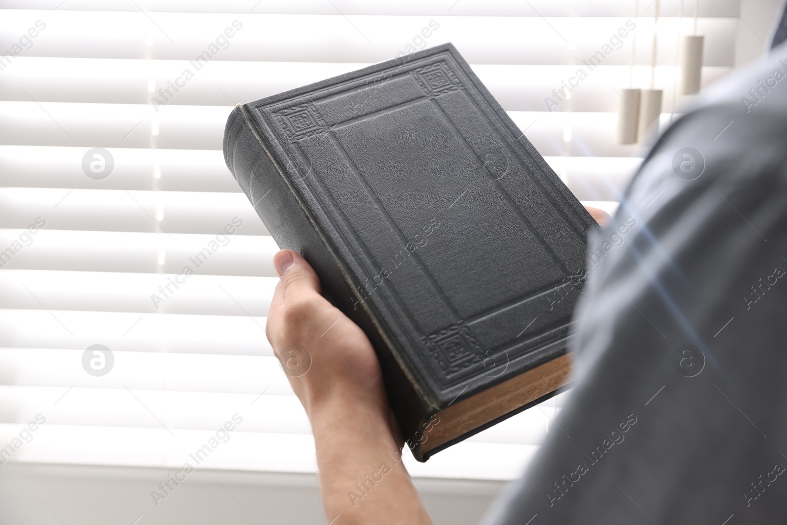 Photo of Man with Bible indoors, closeup. Christian faith