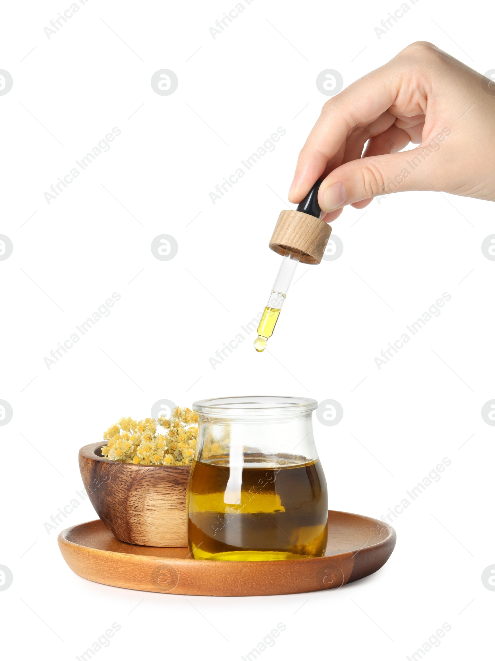 Photo of Woman dripping tincture from pipette into glass jar on white background, closeup