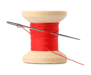 Photo of Spool of red sewing thread with needle isolated on white