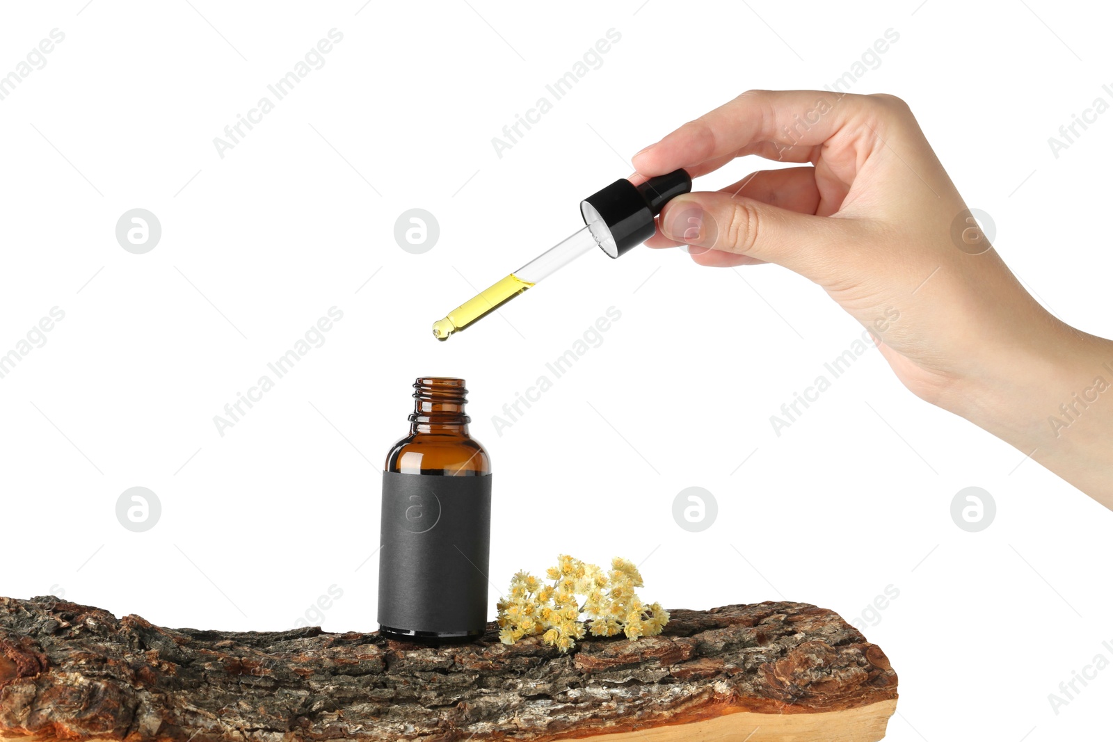 Photo of Woman dripping tincture from pipette into bottle against white background, closeup