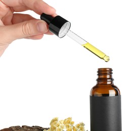 Photo of Woman dripping tincture from pipette into bottle against white background, closeup