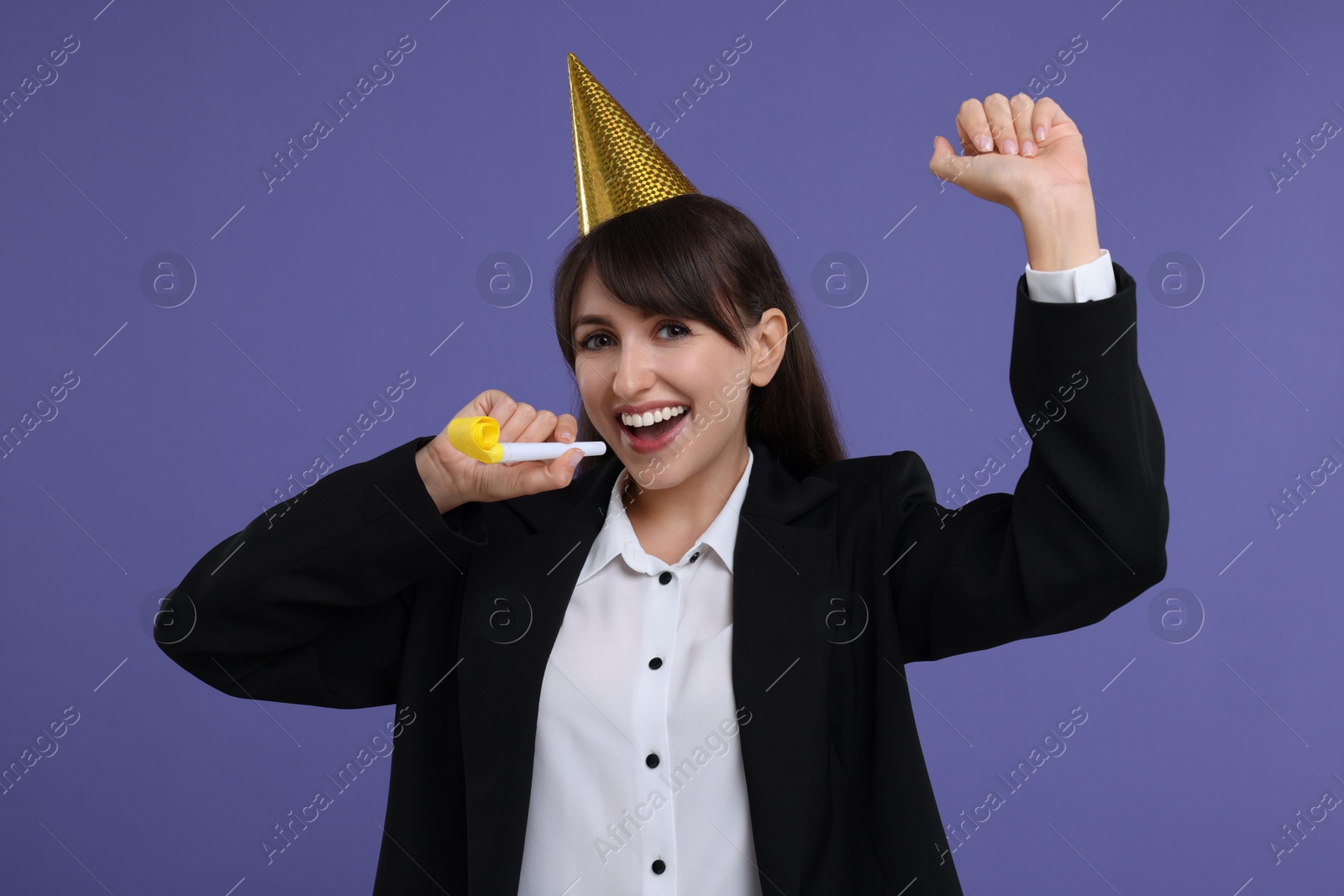 Photo of Woman in party hat with blower on purple background