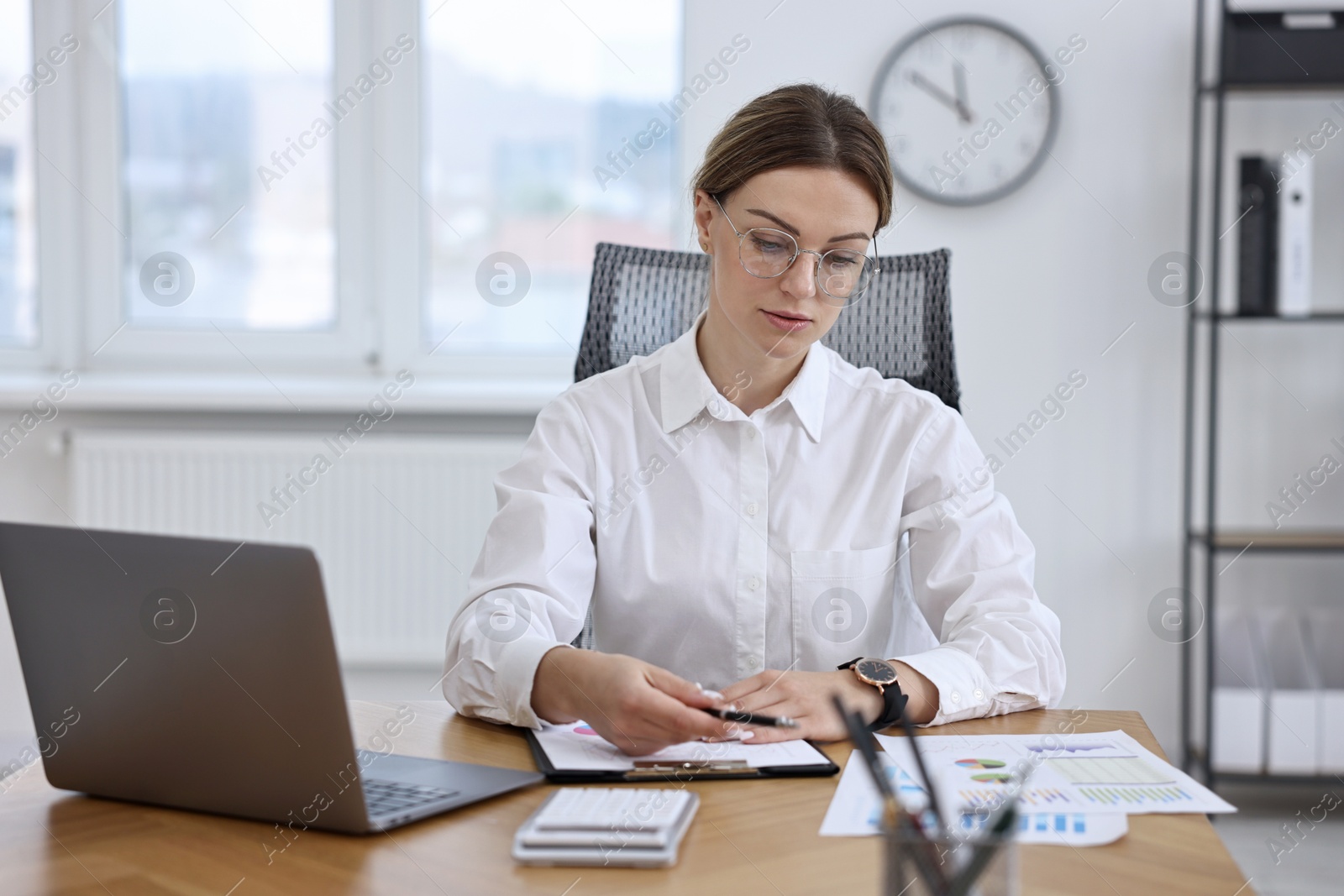 Photo of Banker working at wooden table in office