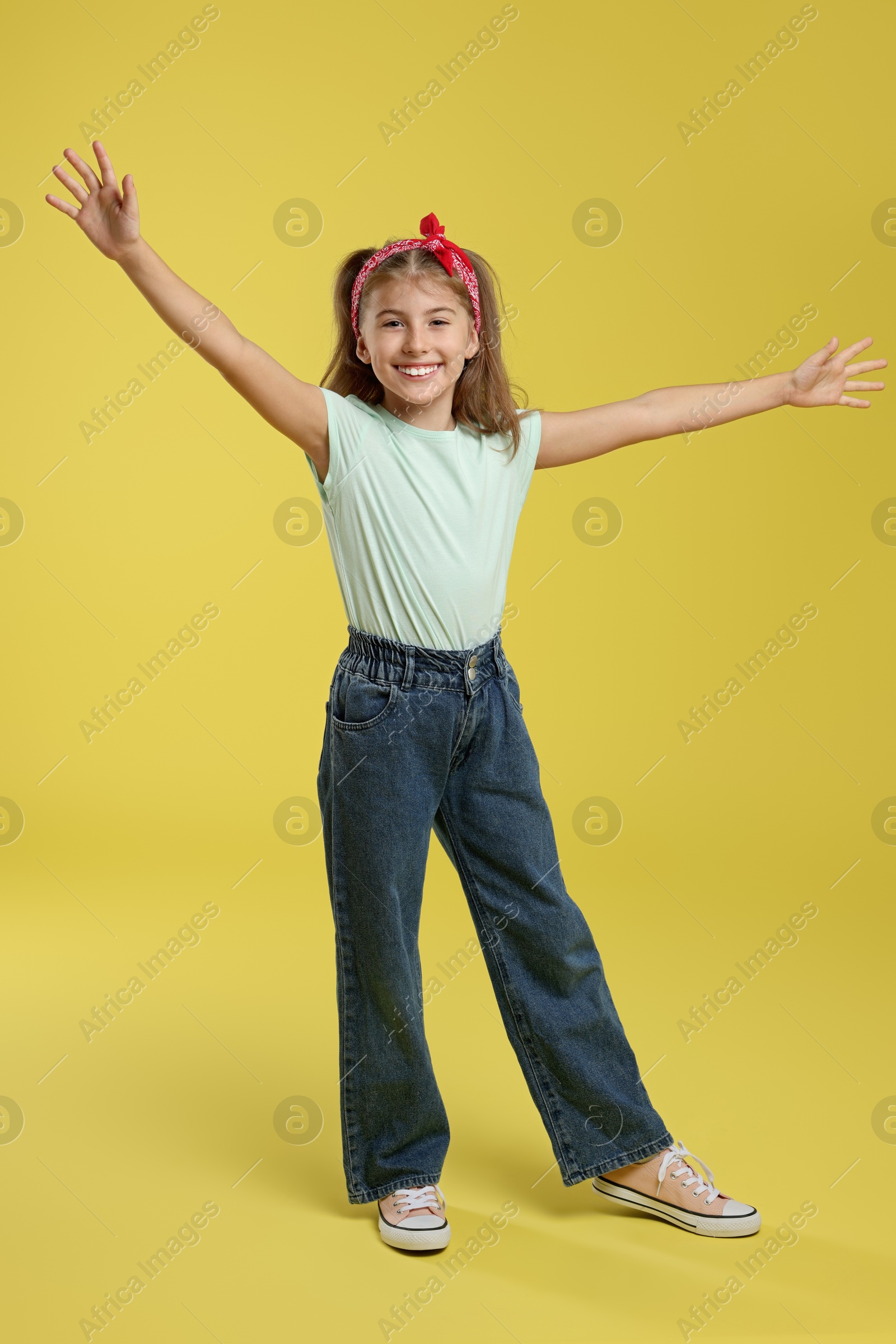 Photo of Full length portrait of cute girl on yellow background