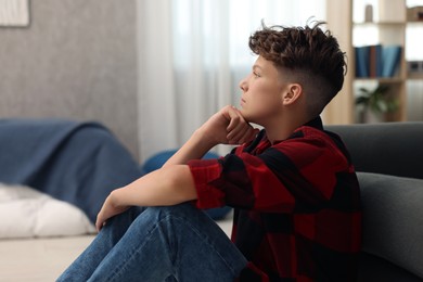 Loneliness concept. Sad teenage boy on floor in bedroom