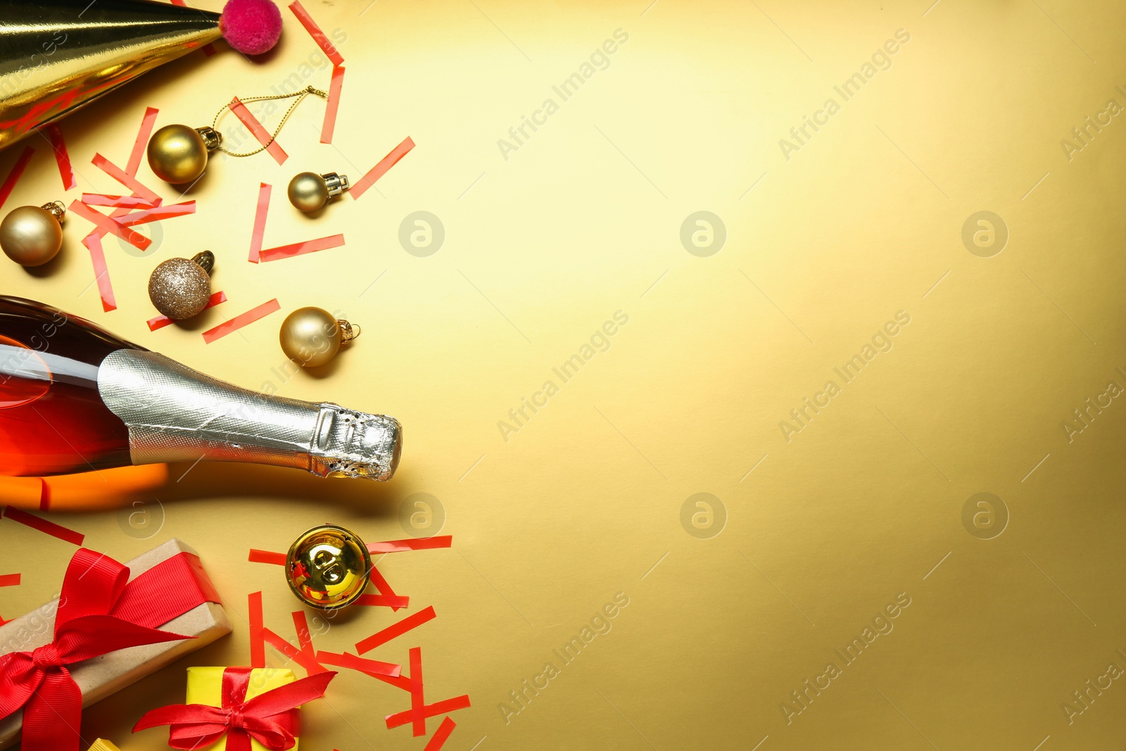 Photo of Flat lay composition with bottle of sparkling wine, confetti and other Christmas decor on beige background. Space for text