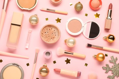 Photo of Different makeup brushes, decorative cosmetics and Christmas decor on pink background, flat lay