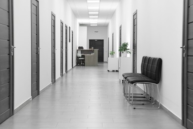 Photo of Empty hospital corridor with chairs and doors