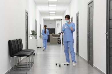 Photo of Nurse with IV drip in hospital hallway