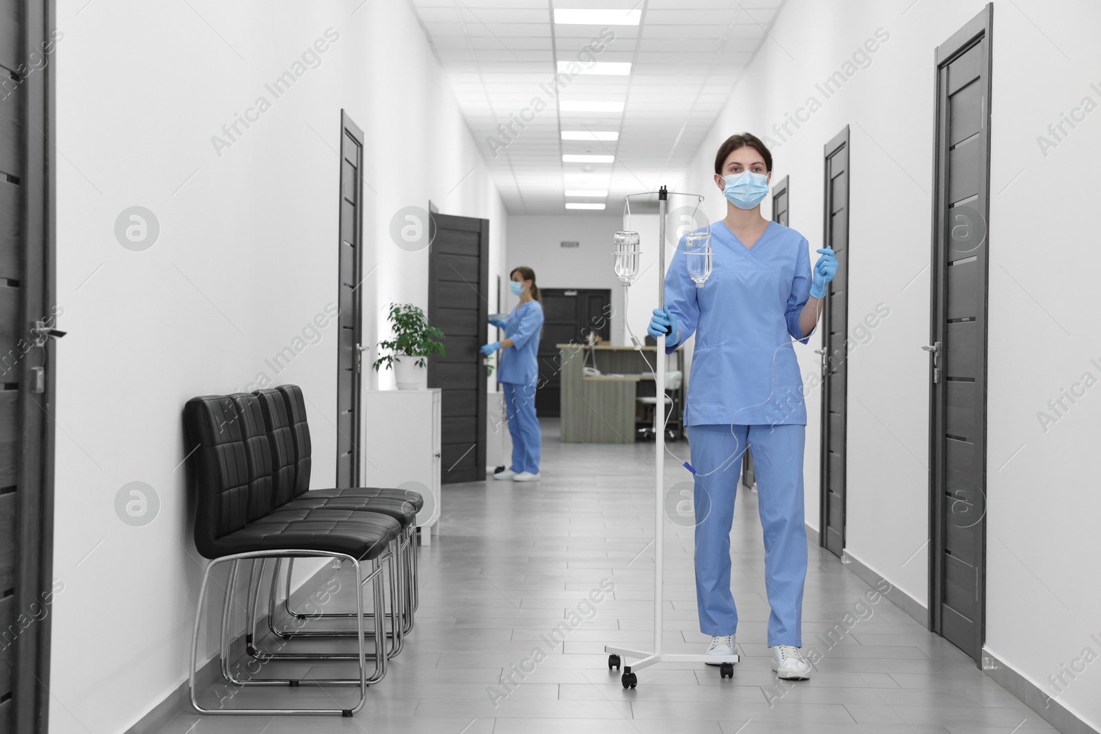 Photo of Nurse with IV drip in hospital hallway