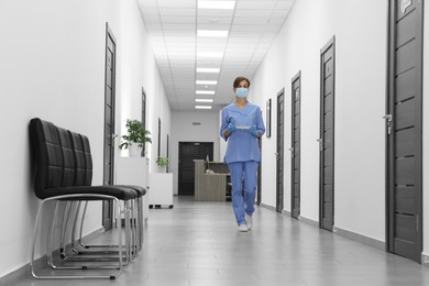 Photo of Nurse in uniform walking in hospital hallway