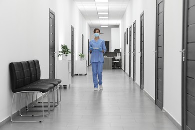 Nurse in uniform walking in hospital hallway