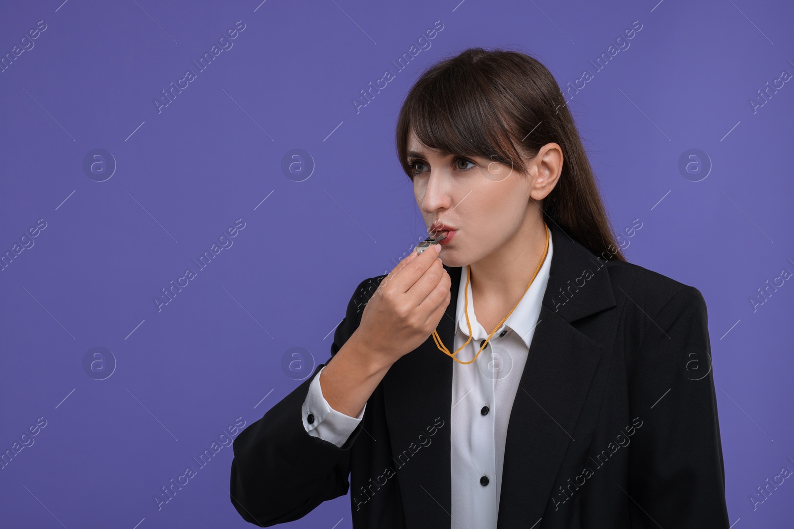 Photo of Woman blowing whistle on purple background, space for text