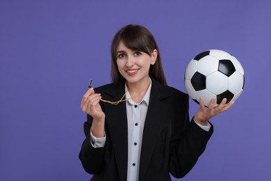 Woman with whistle and soccer ball on purple background