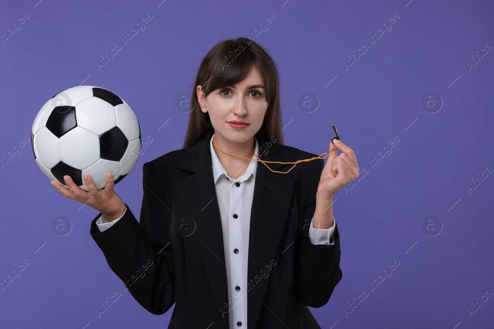 Photo of Woman with whistle and soccer ball on purple background