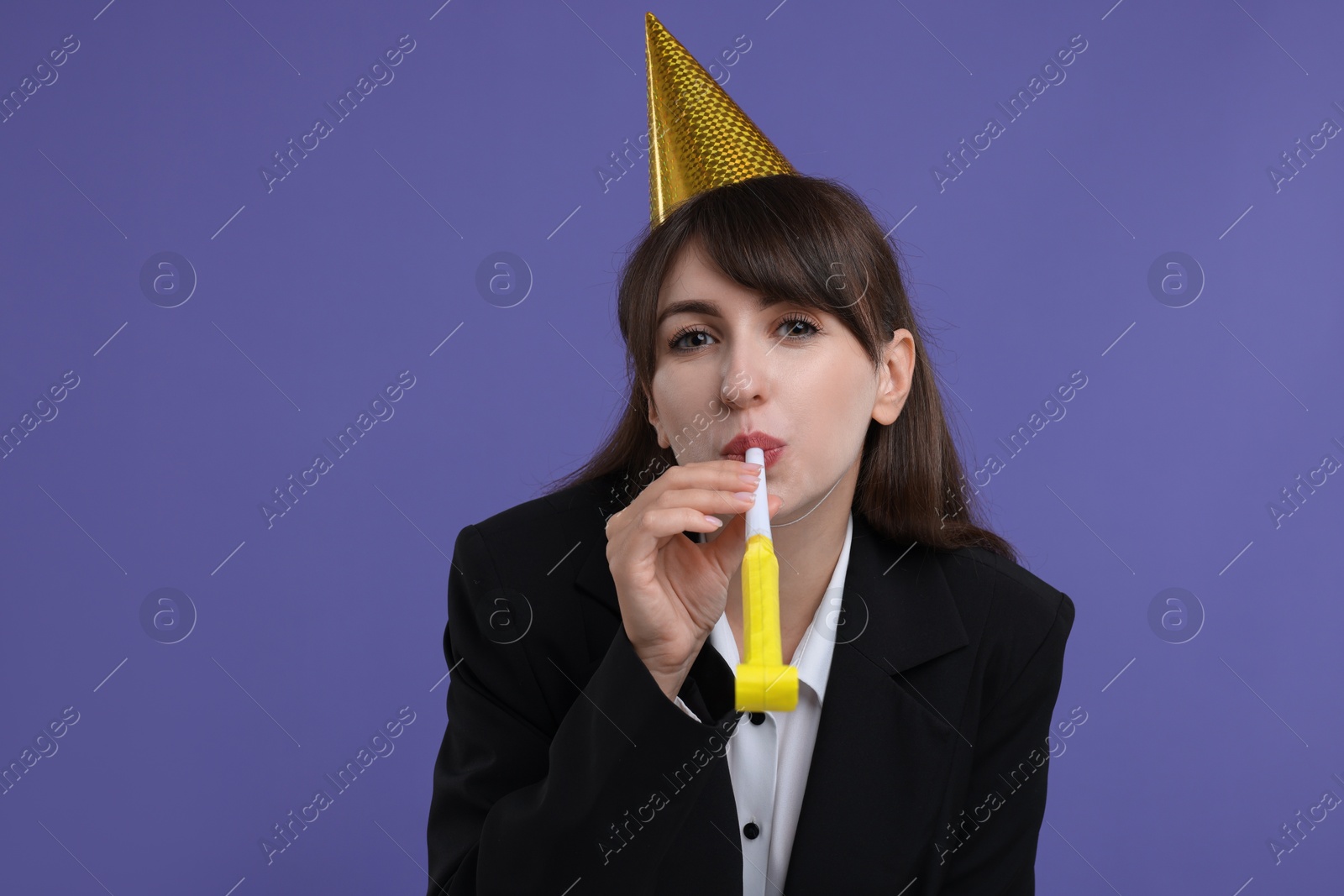 Photo of Woman in party hat with blower on purple background