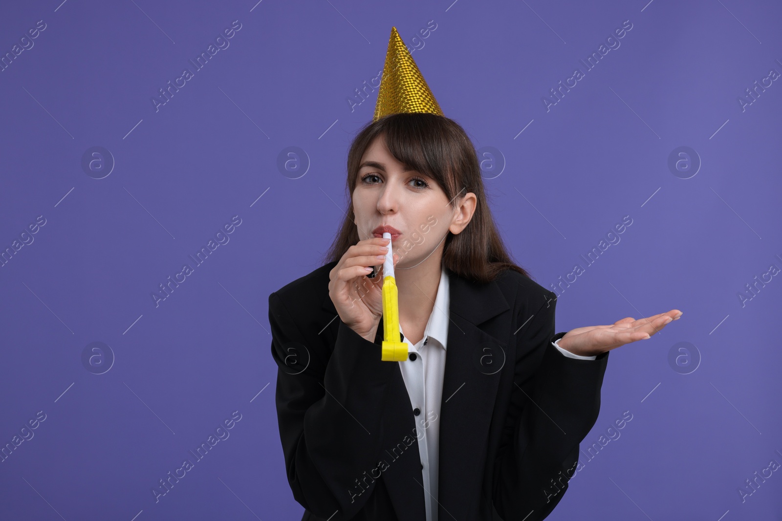 Photo of Woman in party hat with blower on purple background