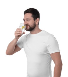 Handsome man drinking water with lemon on white background