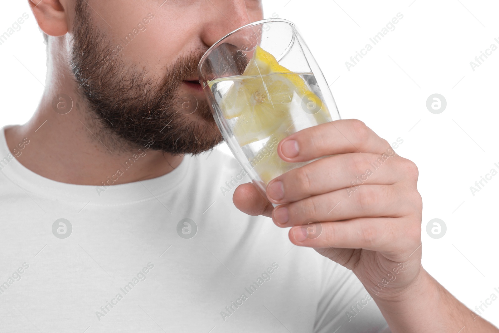 Photo of Man drinking water with lemon on white background, closeup