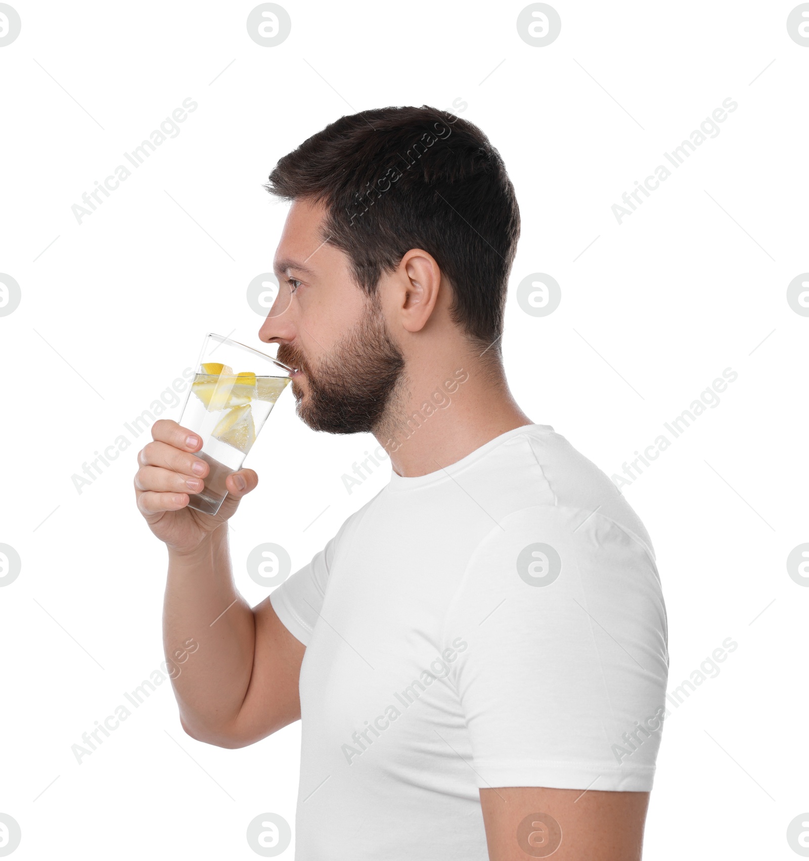 Photo of Handsome man drinking water with lemon on white background