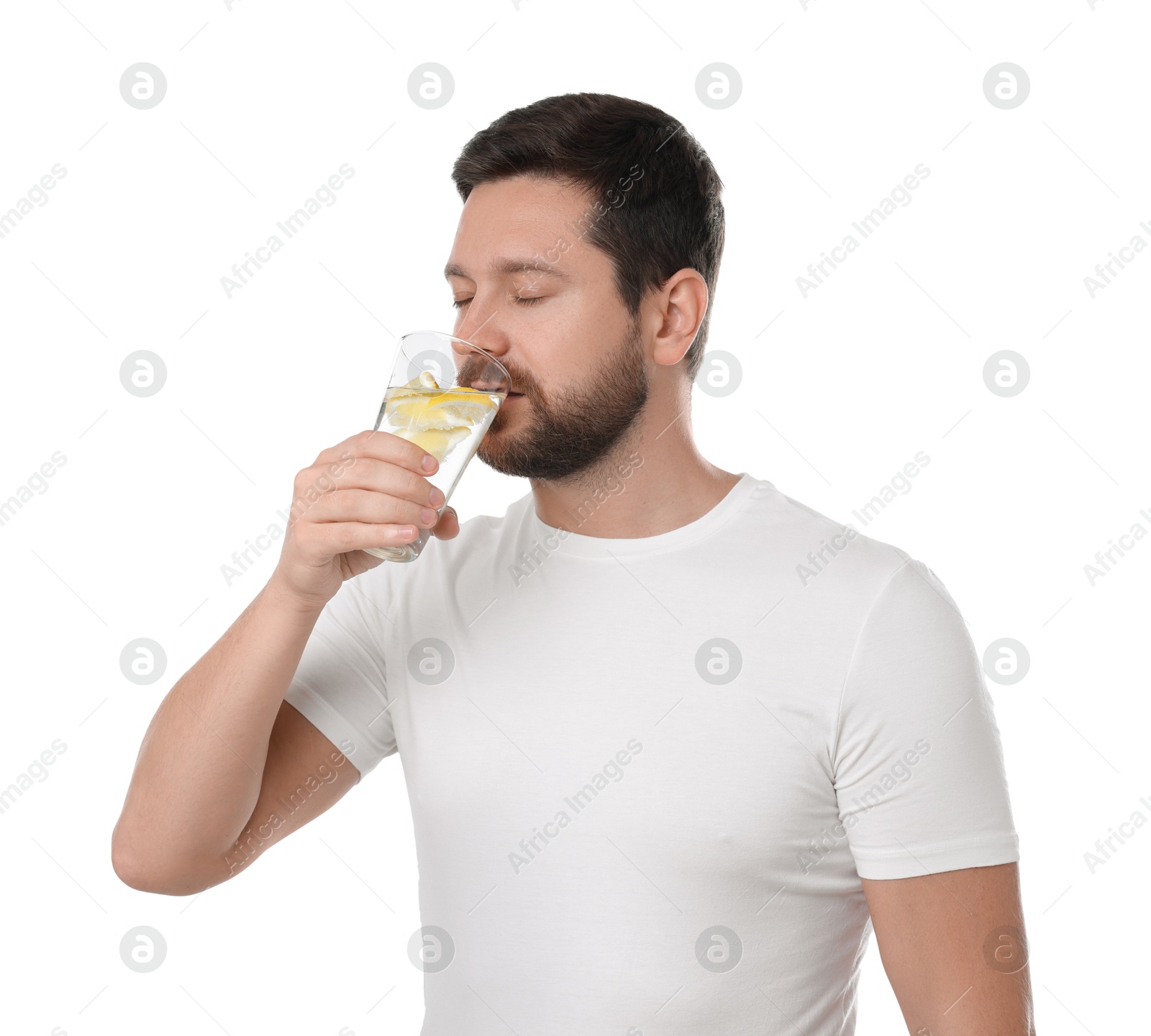 Photo of Handsome man drinking water with lemon on white background