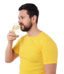 Photo of Handsome man drinking water with lemon on white background