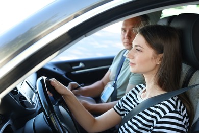 Driving school. Student passing driving test with examiner in car