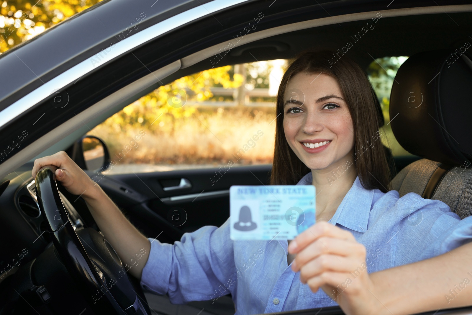 Photo of Driving school. Woman with driving license in car