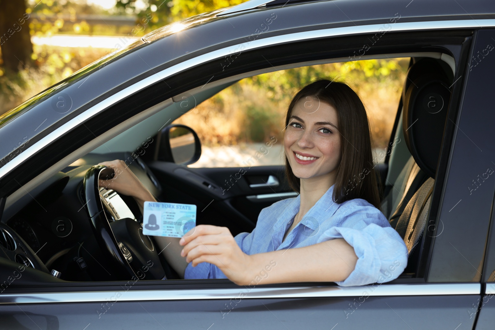 Photo of Driving school. Woman with driving license in car