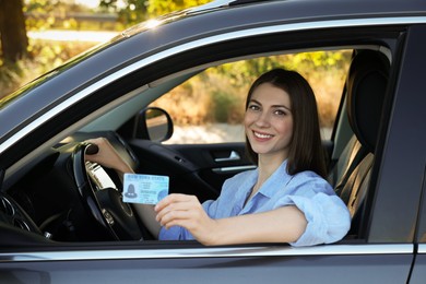 Photo of Driving school. Woman with driving license in car