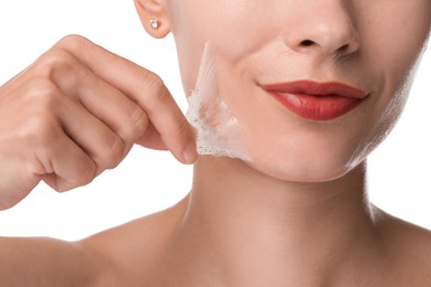 Photo of Woman peeling off face mask on white background, closeup