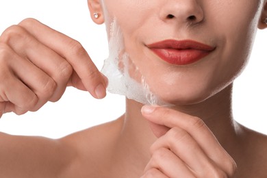 Photo of Woman peeling off face mask on white background, closeup