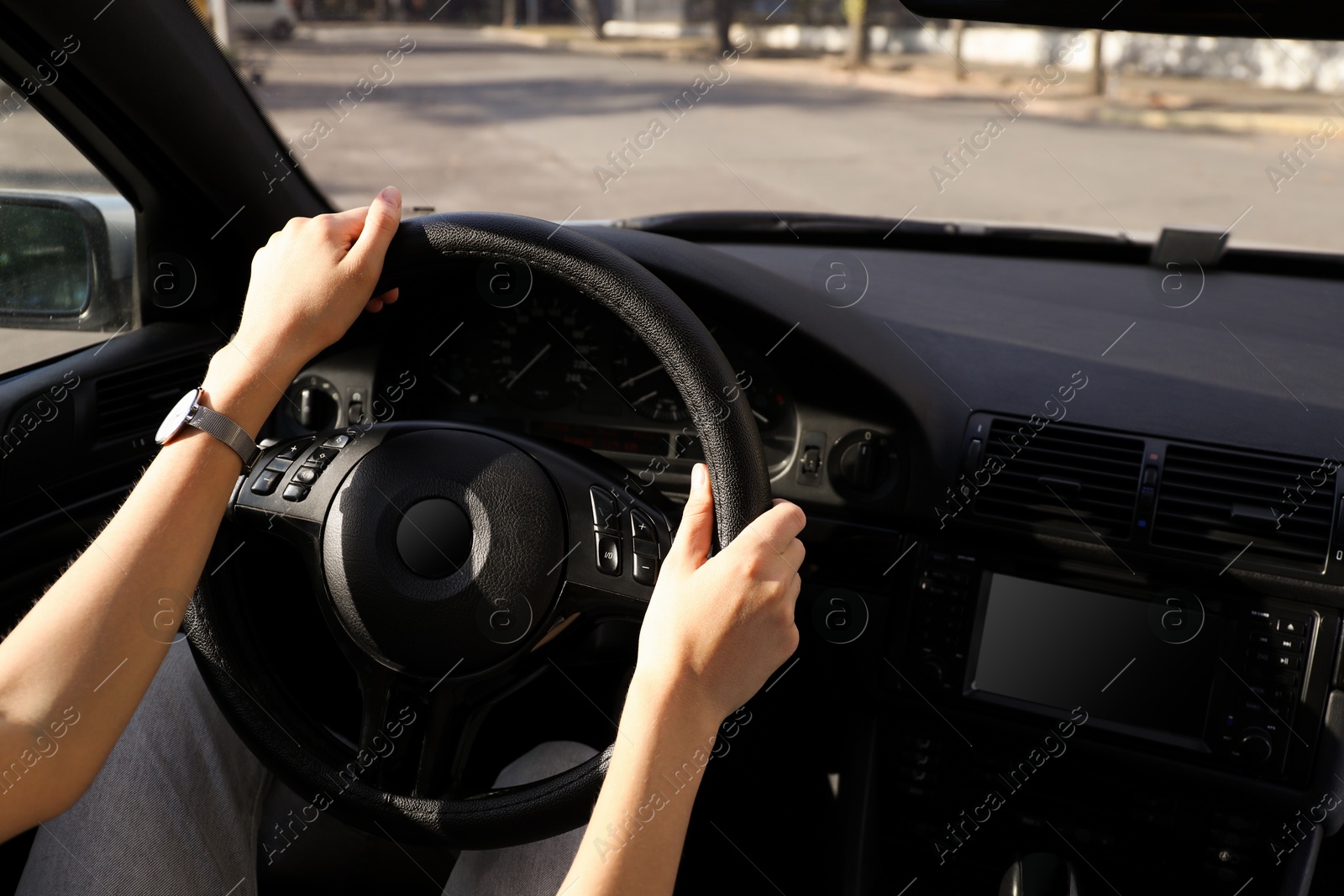 Photo of Woman holding steering wheel while driving car, closeup