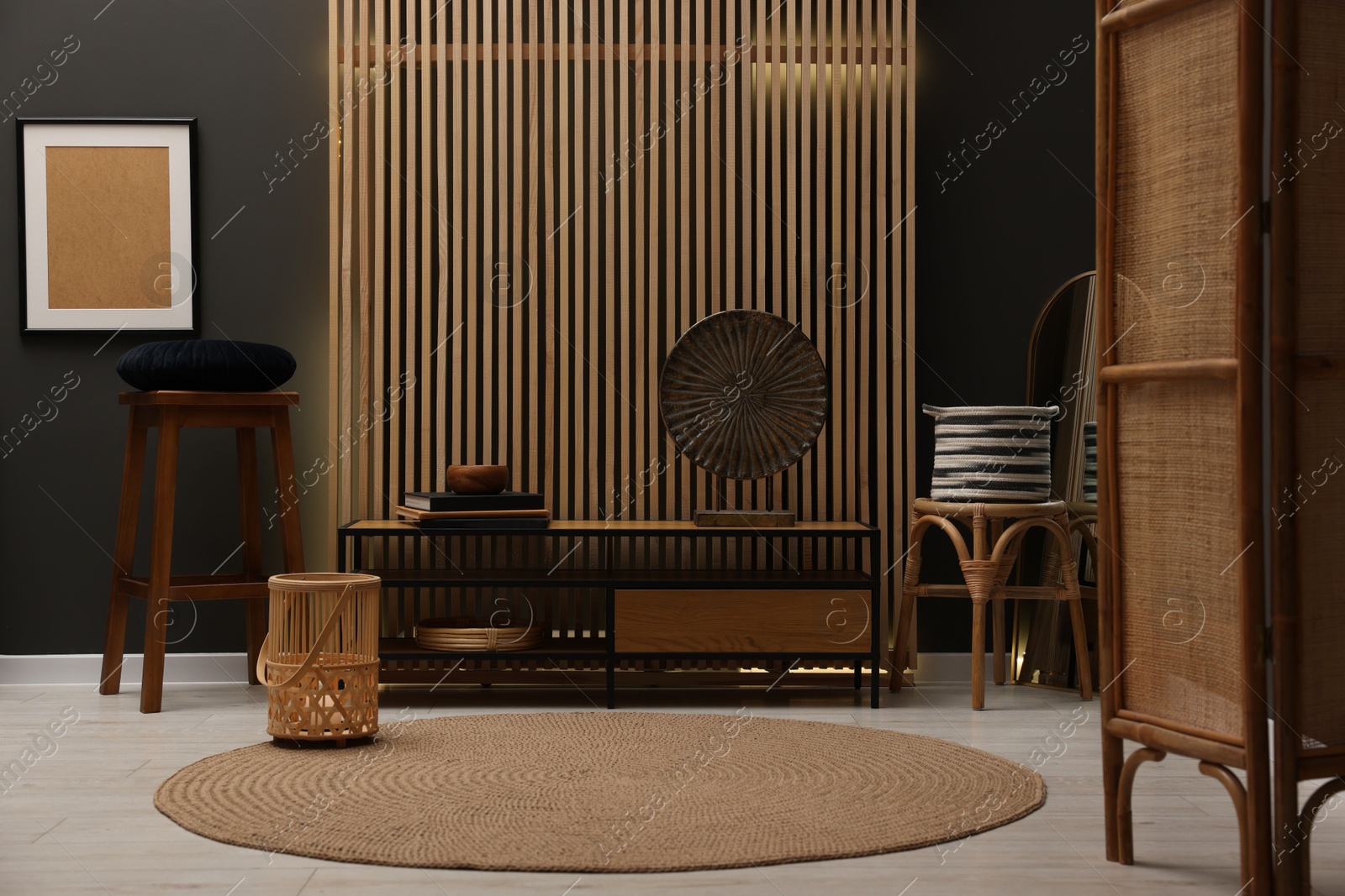 Photo of Stools, wooden cabinet and decor elements in room. Stylish interior design