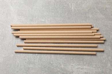 Photo of Bamboo drinking straws on gray textured table, top view