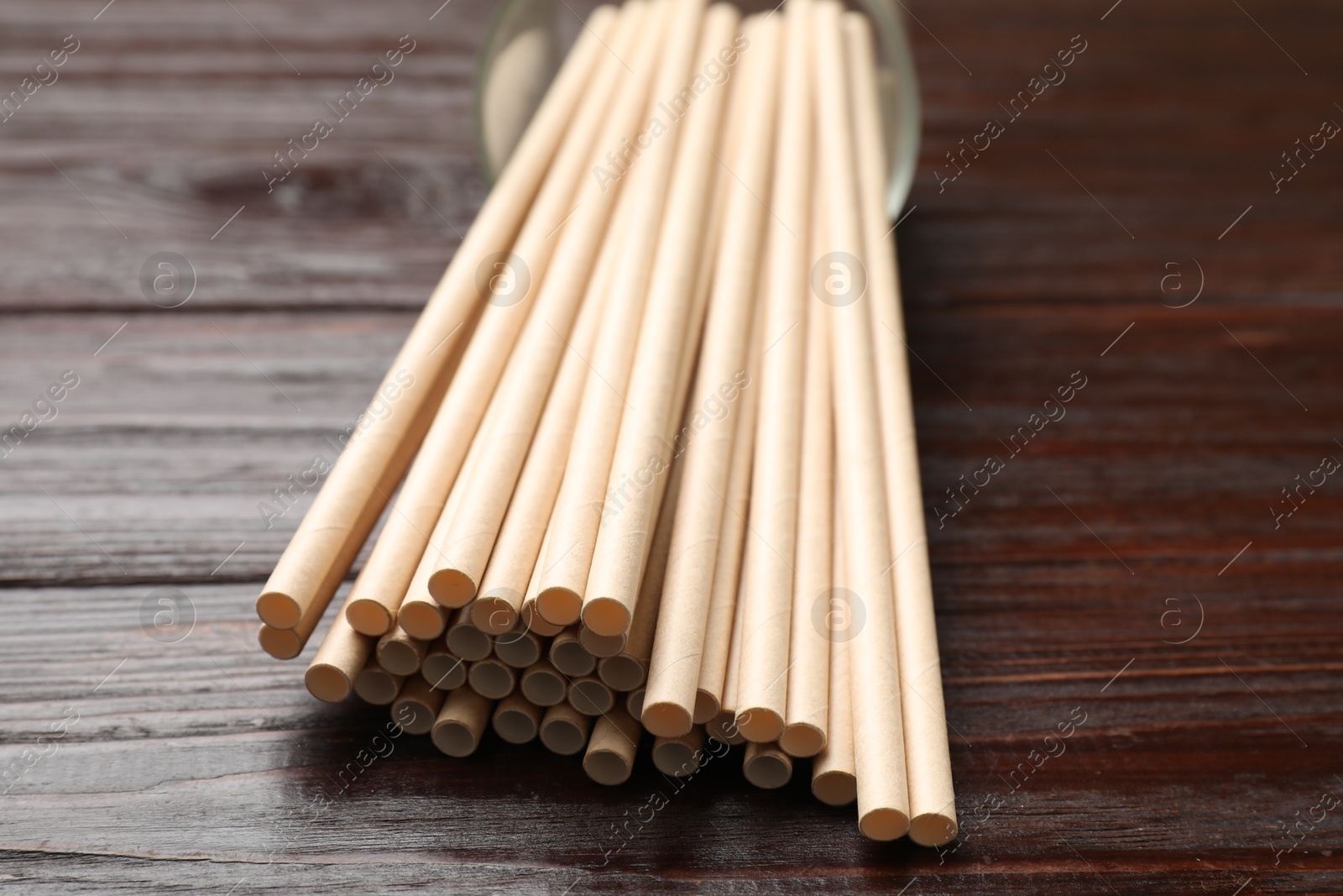 Photo of Bamboo drinking straws on wooden table, closeup