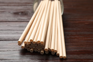 Photo of Bamboo drinking straws on wooden table, closeup