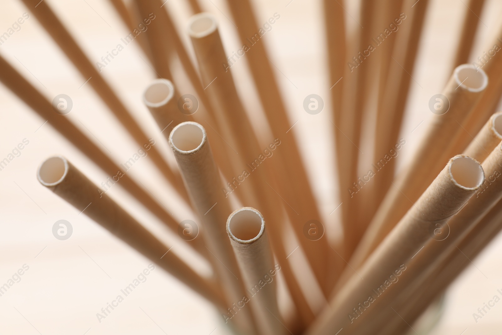 Photo of Bamboo drinking straws on beige background, closeup