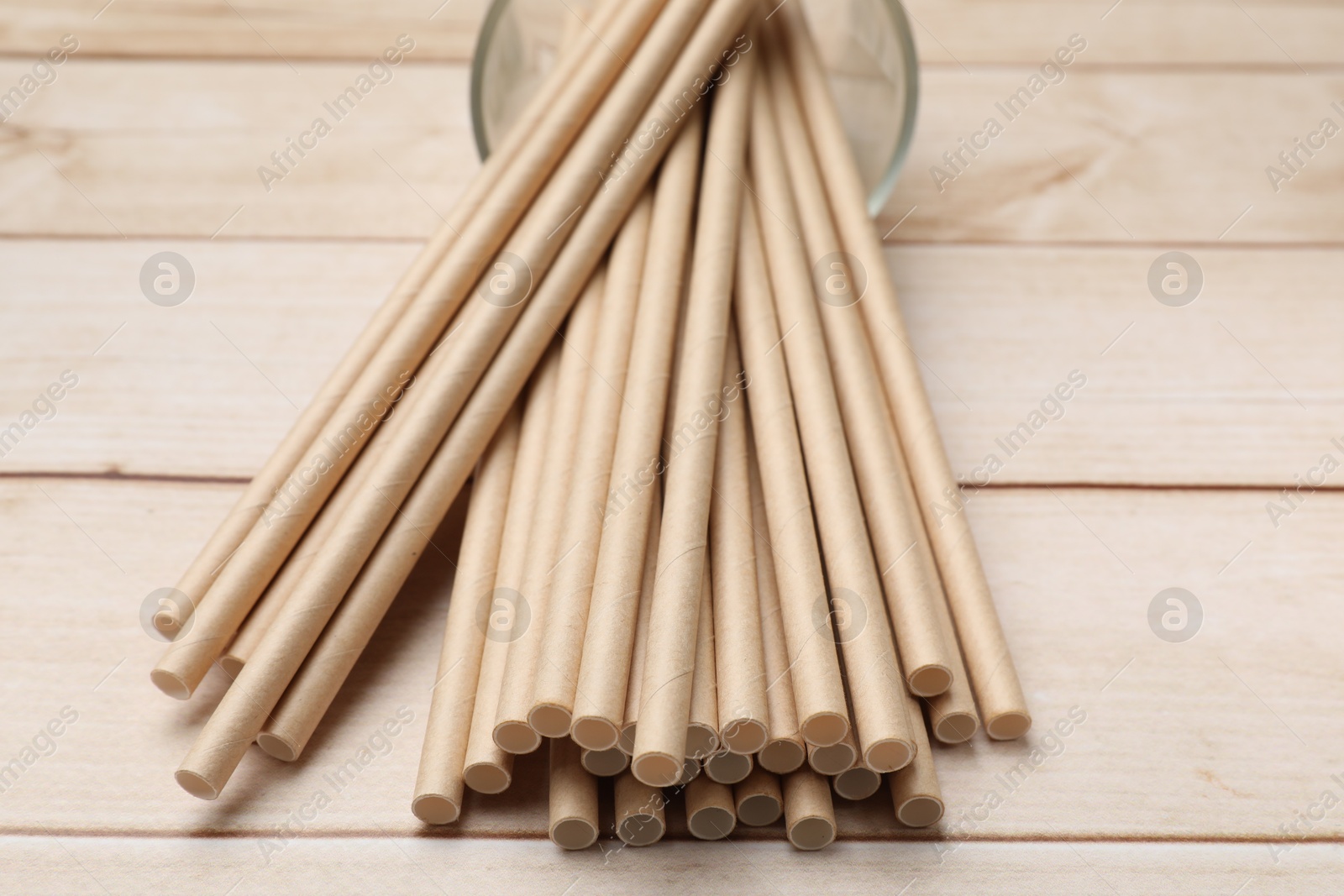 Photo of Bamboo drinking straws on wooden table, closeup