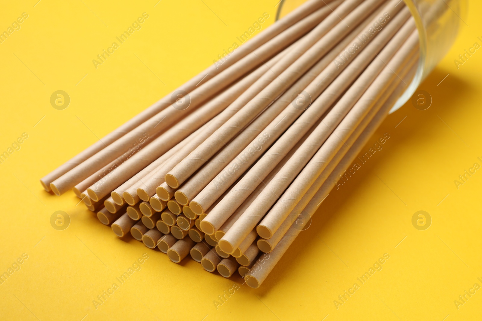 Photo of Bamboo drinking straws on yellow background, closeup