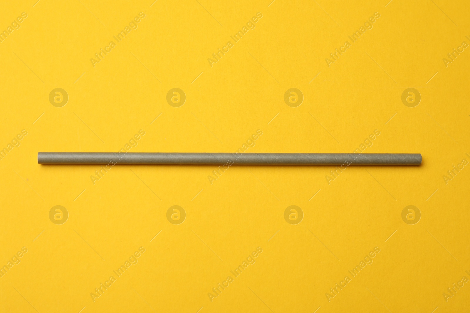 Photo of Bamboo drinking straw on yellow background, top view